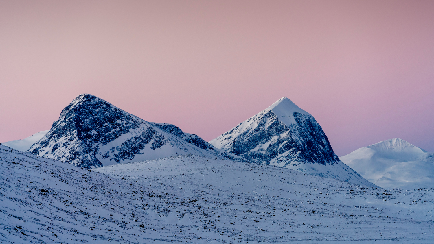 Picure of blue and white mountains in ammarnäs and pink sky 