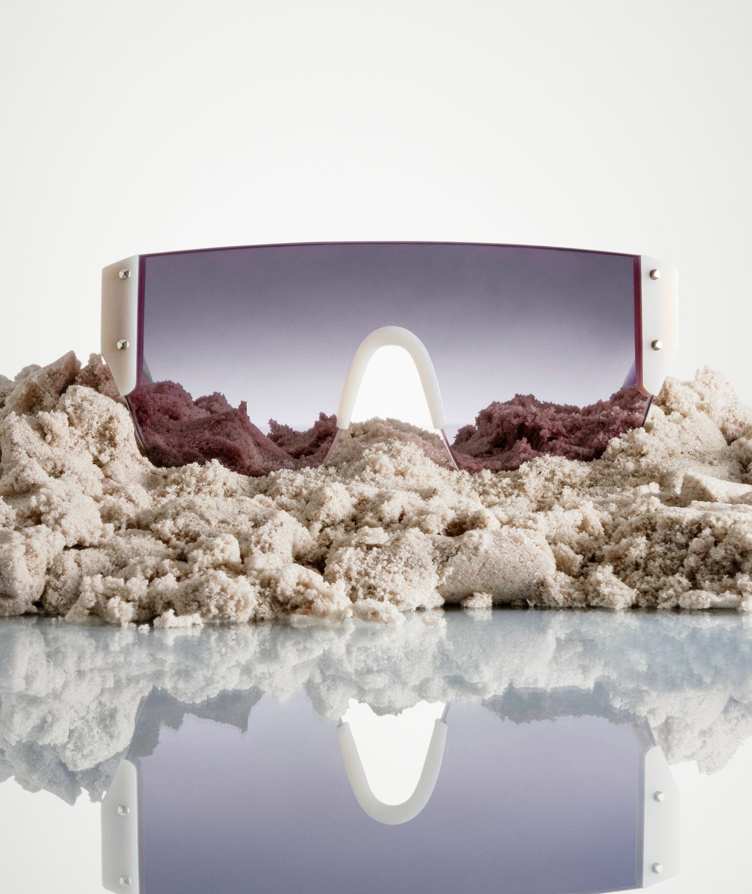 Sunglasses on a bed of sand